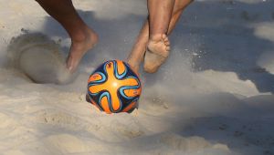 борьба за владение мячом во время пляжного футбола